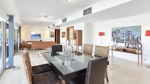 A modern dining area with a glass-top table, wicker chairs, and a sofa in the background. - Villa With Private Pool in the Golf Resort (San Bartolomé de Tirajana)