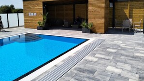A modern building with a covered outdoor area, a swimming pool, and outdoor seating. - Summer House in Jaroslawiec Near Beach & Pool (Postomino)