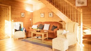 A cozy wooden interior with a sofa, armchairs, a coffee table, and a staircase. - Doppelhaushalfte in Hasselfelde (Oberharz am Brocken)