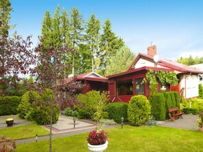 Una casa de madera roja con un jardín delantero.
