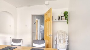 Een moderne keuken met een houten tafel, stoelen en een verschoonmogelijkheid voor baby's.