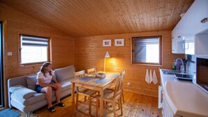 A cozy cabin with a wooden interior, a dining area, and a kitchenette. - Bungalow in Miedzyzdroje Near Baltic Beach (Miedzyzdroje)
