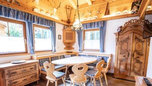 A wooden dining room with a round table and chairs, a wooden cabinet, and a bench. - Chalet in Austria Near Ski Lift & Forest (Wald im Pinzgau)