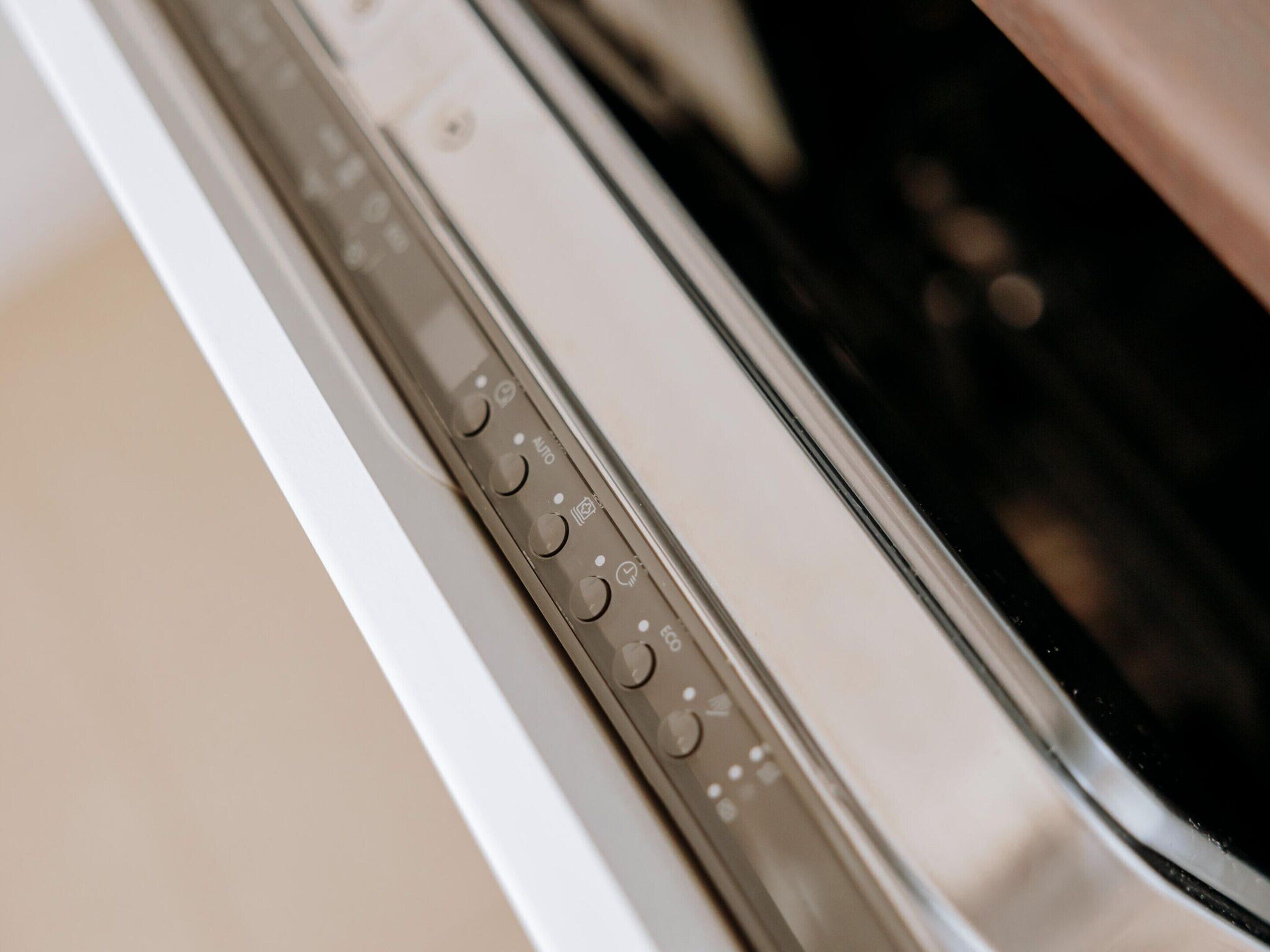 A close-up of a dishwasher control panel with various buttons and settings.