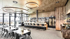 A modern restaurant with a bar area, seating arrangements, and a view of the mountains. - Apartment in Kaltenbach With Ski-in/ski-out (Kaltenbach)