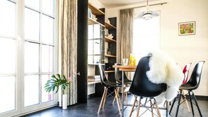 Een eethoek met een tafel, stoelen en een potplant.