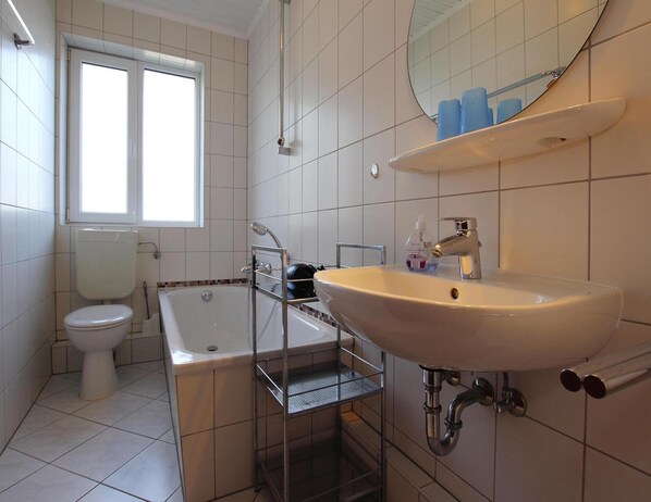 A bathroom with a bathtub, toilet, and sink.