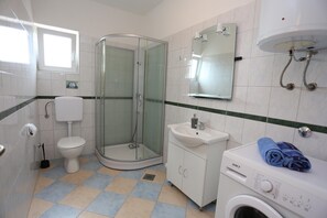 A bathroom with a glass-enclosed shower, a toilet, a sink, and a washing machine. - Apartment in Kakma Near Biograd Beaches (Polaca)