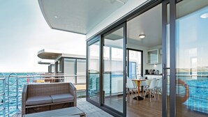 Ein Schiffsdeck mit Essbereich, einer Sitzecke und Blick auf den Pool.