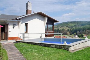 A house with a swimming pool, a brick pathway, and a view of a forested hill. - Ferienhaus, Waldau Thuringen (Schleusingen)