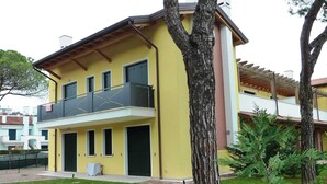 A two-story yellow building with a balcony on the upper floor. - Villa Faro Vecchio in Cavallino-treporti-formerly TUI Ferienhaus (Cavallino-Treporti)