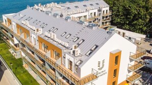 Ένα πολυώροφο ξενοδοχείο με μοντέρνο σχεδιασμό, που διαθέτει μπαλκόνια και μια ταράτσα.