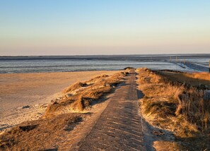A coastal path leading to the sea with a clear sky. - Ferienwohnung Tiefblick, Dornumersiel (Dornum)