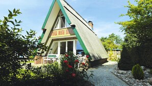 A house with a steeply pitched roof, brick walls, and a small porch with a white railing. - Thatched Holiday Home in Freest With Terrace (Kröslin)