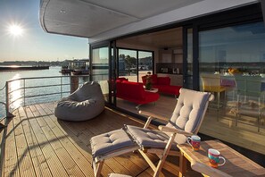 A modern deck with seating and a view of the water. - Haus in Ribnitz Damgarten for 3 Personen (Ribnitz-Damgarten)