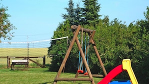 Un'area giochi con altalene e uno scivolo.