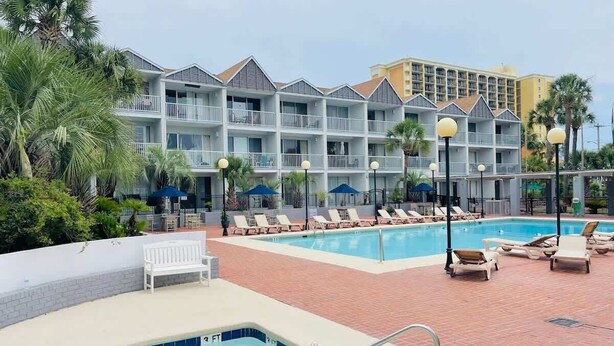 A hotel with a pool area, including a hot tub and lounge chairs. - SJ15 Cozy studio close to the beach (Myrtle Beach)