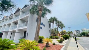 A hotel with a white facade, multiple balconies, and palm trees in the foreground. - SJ15 Cozy studio close to the beach (Myrtle Beach)