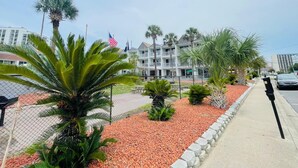 A hotel with multiple balconies, palm trees, and a parking area. - SJ20 Cozy studio close to the beach (Myrtle Beach)
