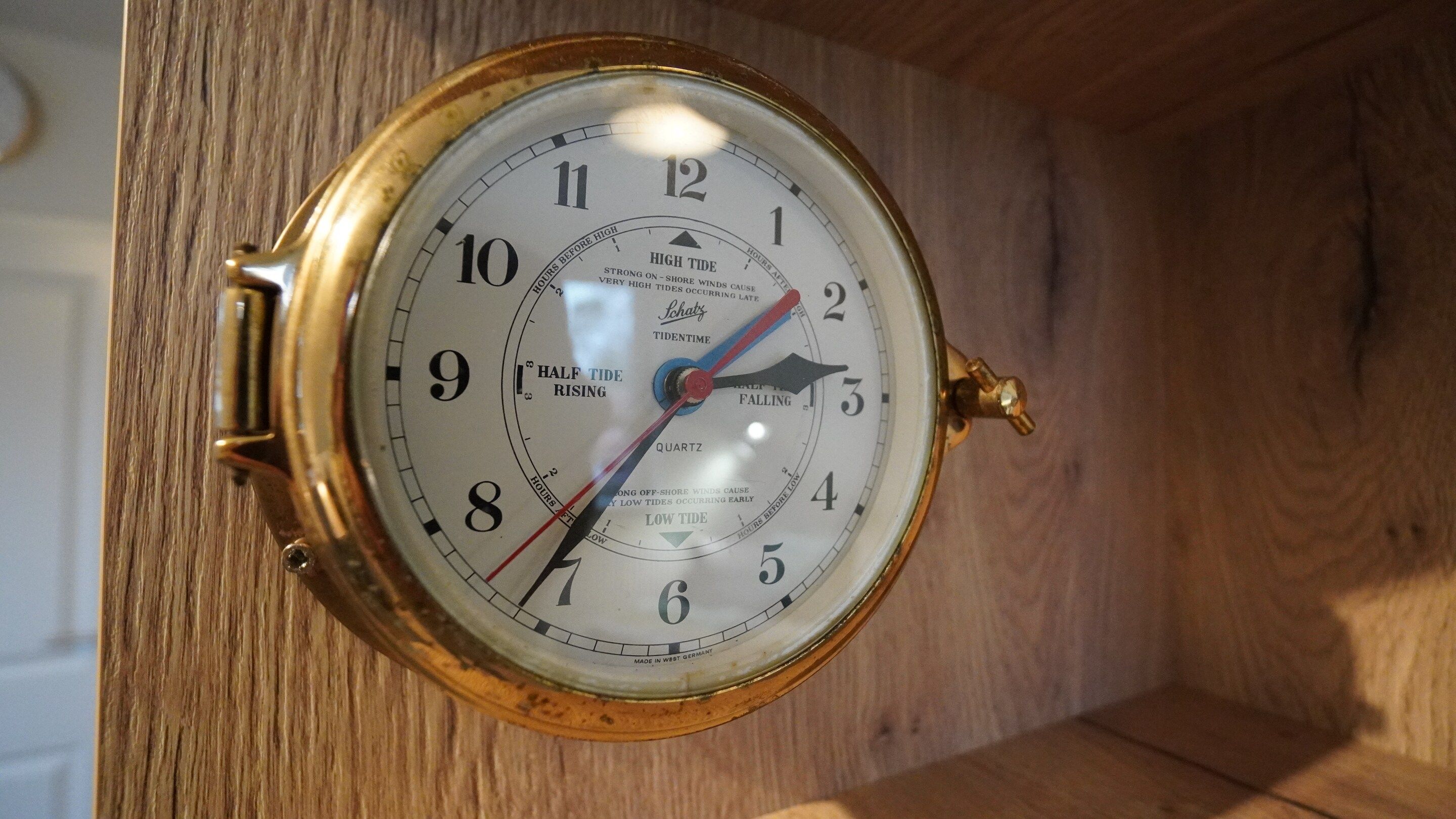 A wall-mounted clock with a white face and black numerals, indicating time.