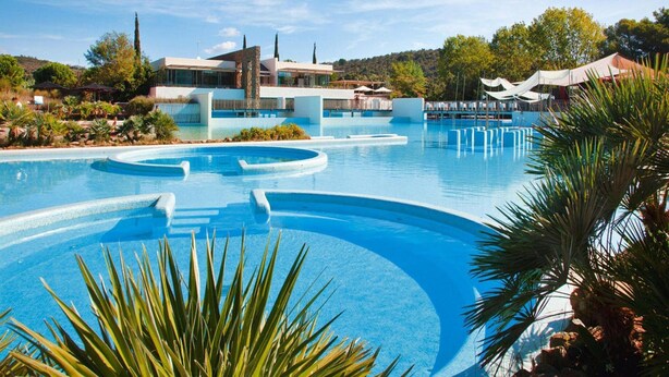 A large outdoor swimming pool with a modern architectural setting, surrounded by greenery and a clear sky. - Resort Village Rocchette Castiglione Della Pescaia (Castiglione della Pescaia)