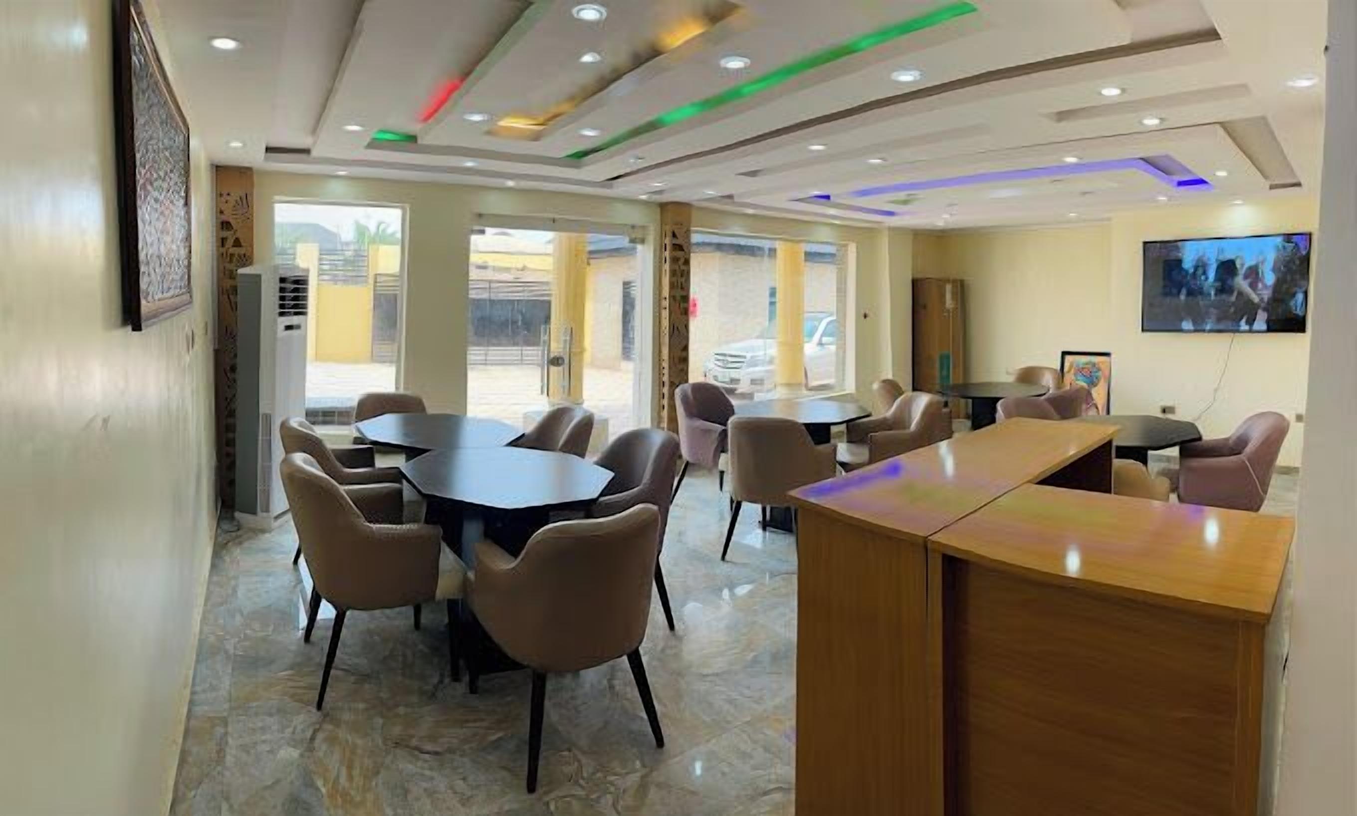 Une salle de conférence équipée d’une grande table et de chaises, d’un téléviseur et d’un buffet en bois.