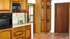 A kitchen with wooden cabinets, a microwave, and a stove. - Ferienwohnung in der Nahe vom Hexentanzplatz (Thale)