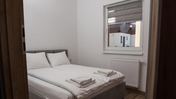 A bedroom with a bed, a window, and a radiator. - Comfortable Ground Floor Apartment, Summer Pool (Postomino)