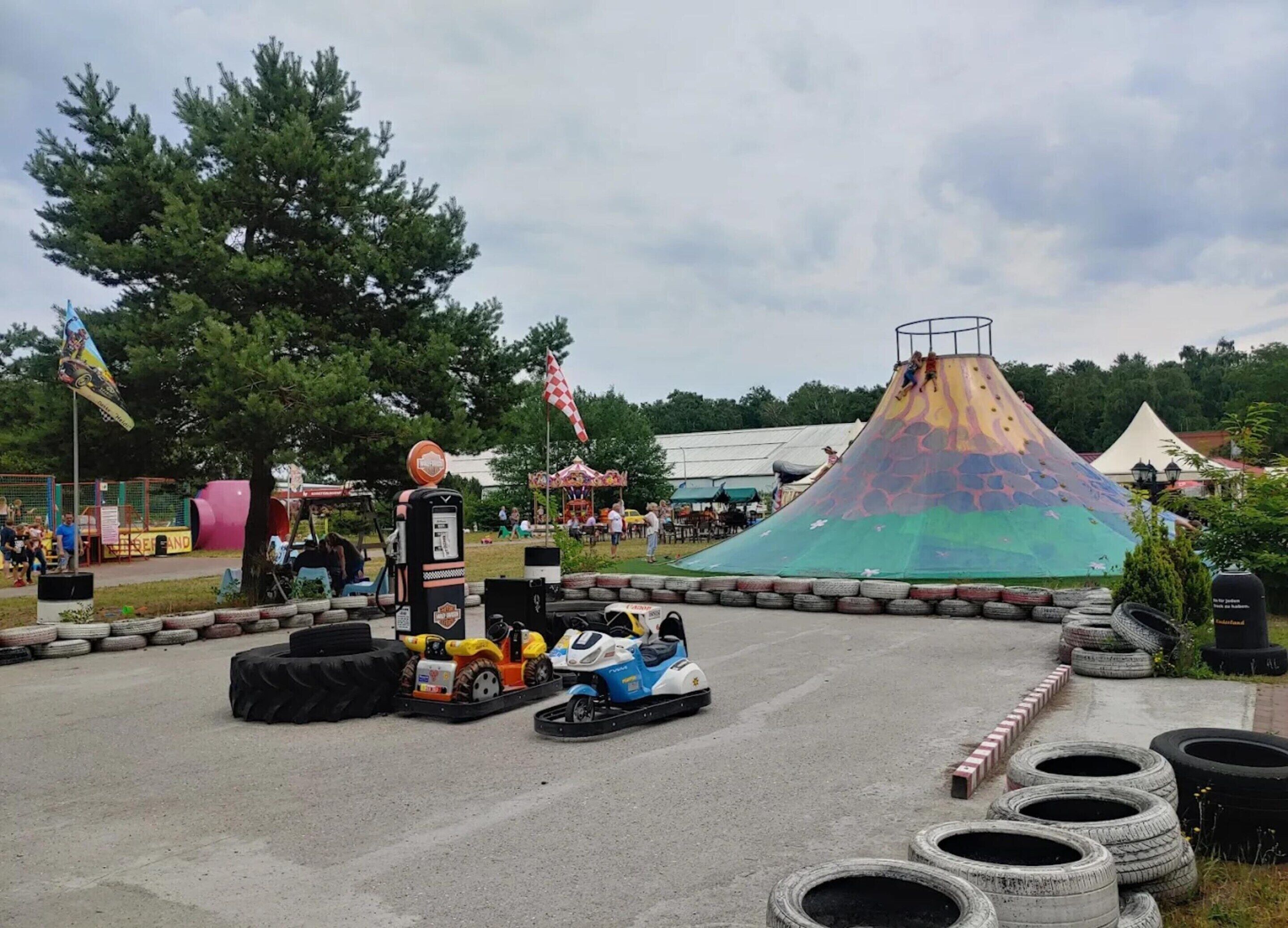 A go-kart track with a colorful ramp and a tire barrier.