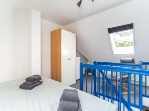 Une pièce comprenant un lit, une armoire, un bureau et une fenêtre.