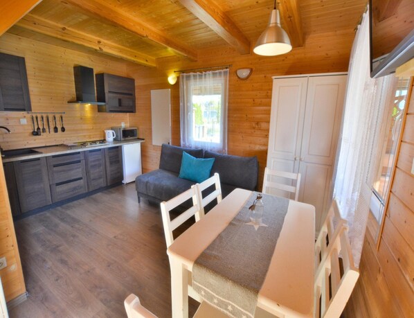 A cozy cabin interior with a kitchenette, a dining area, and a sofa. - Two-storey Holiday Home in Ustronie (Ustronie Morskie)