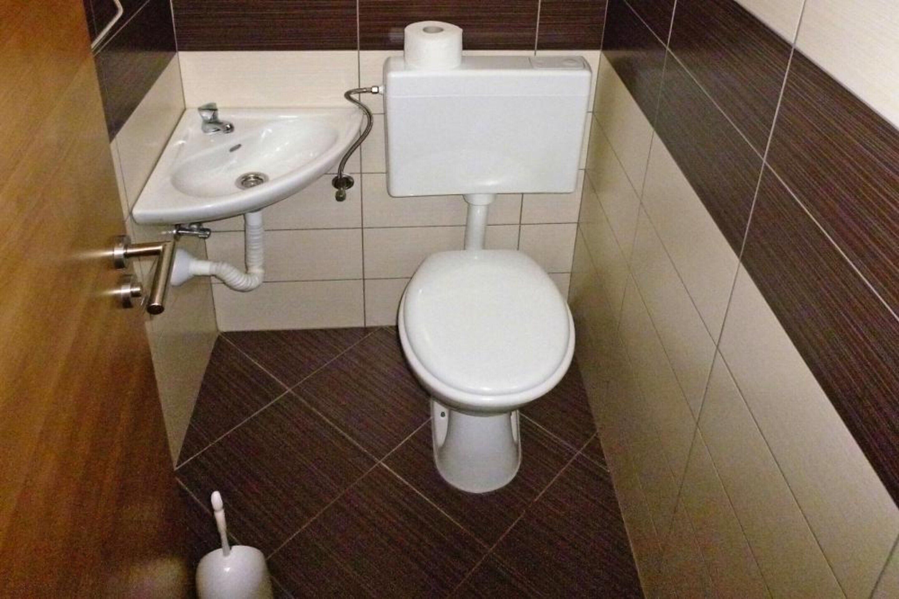 Une salle de bain équipée de toilettes, d’un lavabo et de papier toilette.