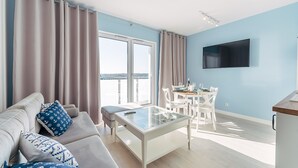A modern living room with a sofa, coffee table, and dining area. - Comfortable 2-room Apartment, Grzybowo (Kolobrzeg)