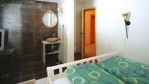 A bedroom with a bed, a bedside table, a mirror, and a bathroom with a sink and shower. - Chalet in Konigsleiten With Wellness & Alps View (Krimml)