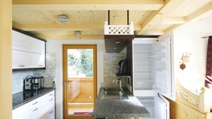 A compact kitchen with white cabinets, a granite countertop, a built-in oven, and a window overlooking greenery. - Chalet in Konigsleiten With Wellness & Alps View (Krimml)
