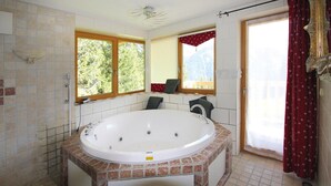 A bathroom with a large bathtub, a window with a view of greenery, and a shower area. - Chalet in Konigsleiten With Wellness & Alps View (Krimml)