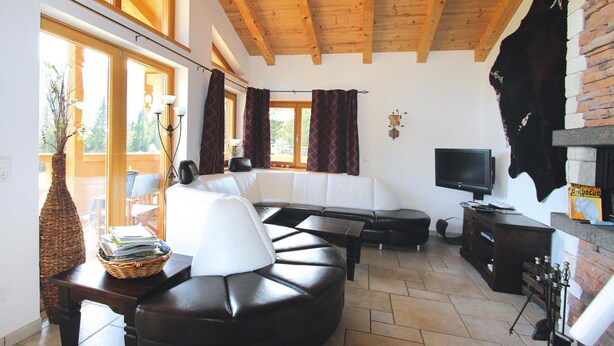 A modern living room with a large sectional sofa, a flat-screen TV, and a fireplace. - Chalet in Konigsleiten With Wellness & Alps View (Krimml)