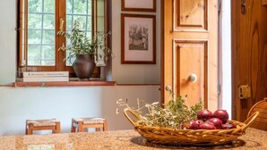 A kitchen with a granite countertop, a wicker basket with vegetables, a potted plant, and framed pictures on the wall. - Villa Privata "Forre 563 " (Reggello)