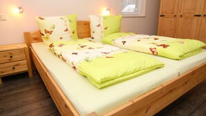 A double bed with a wooden frame, two nightstands, and a window with a view. - Wohnung in Lubben im Spreewald fur 4 Personen (Lübben (Spreewald))
