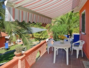 Enjoy a romantic meal for two on this balcony with a table set amidst lush greenery.