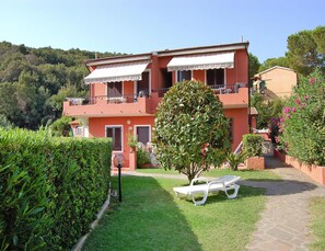 Relax in the serene garden, surrounded by lush greenery and a single tree providing shade.