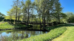 A serene park with a pond, trees, and a bridge. - Reihenhaus in Lubben an der Spree (Lübben (Spreewald))