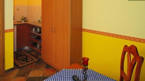 A compact kitchen with a wooden cabinet, a small sink, and a tiled backsplash. - Reihenhaus in Lubben an der Spree (Lübben (Spreewald))