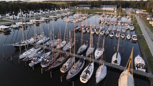 A marina with numerous boats docked, surrounded by buildings and greenery. - Haustierfreundliches Haus auf der Insel Usedom (Peenemünde)
