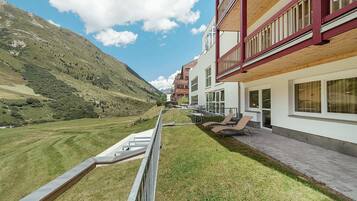 Un edificio moderno con un balcón que da a un paisaje montañoso.