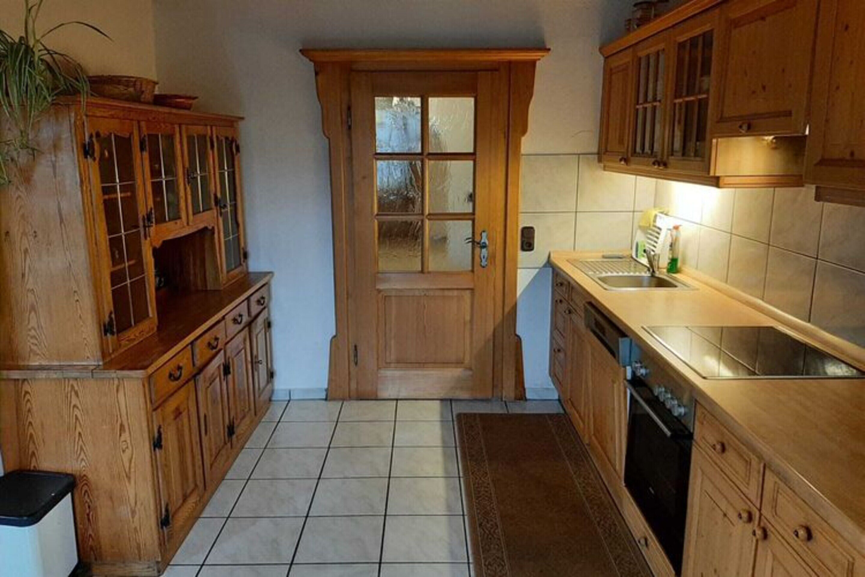 A kitchen with wooden cabinets, a tiled floor, and a built-in oven.