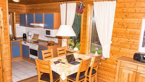 Eine Holzhütte mit Küche, Essbereich und einer kleinen Wohnstube.