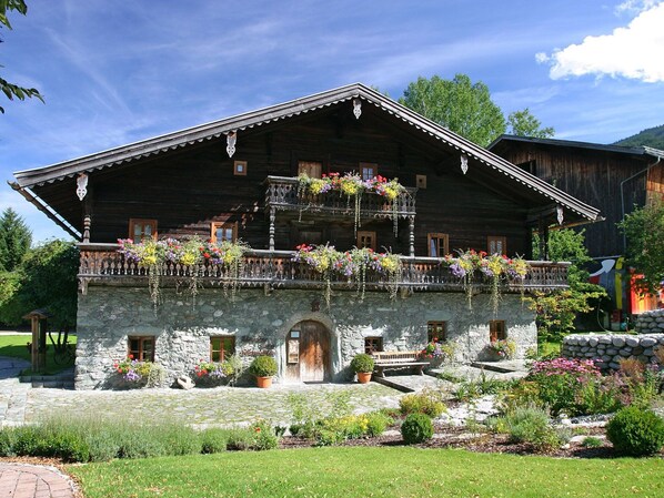 Traditional Alpine-style house with a balcony and stone pathway.