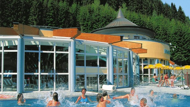 A swimming pool area with a glass building and a covered structure. - Apartment in Filzmoos Near Ski Amade (Filzmoos)