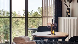 Una habitación acogedora con una mesa redonda, dos copas de vino y una botella.
